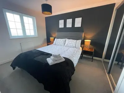 a bedroom with a black and white bed and two windows at Niche View in Irvine