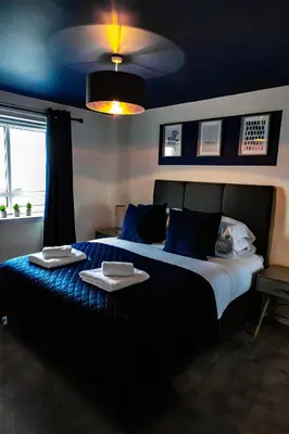 a bedroom with a large bed with two plates on it at The Marine - Balcony - Beach View - Coorie Doon Stays in Ayr