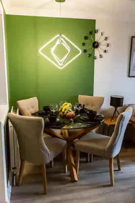 a dining room with a table and a green wall at The Marine - Balcony - Beach View - Coorie Doon Stays in Ayr