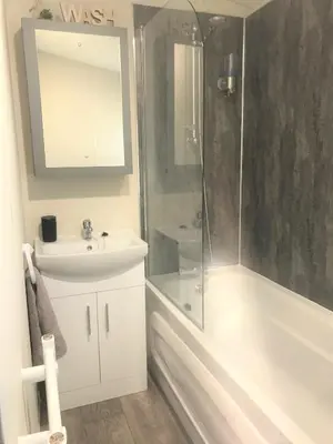 a bathroom with a shower and a sink and a tub at Cumbria Reach in Longtown