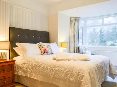 a bedroom with a large bed with a window at Parkfield in Keswick