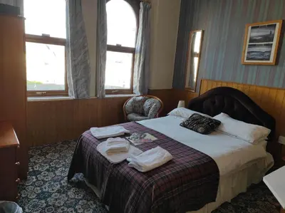 a hotel room with a bed with towels on it at All Seasons Guesthouse in Douglas