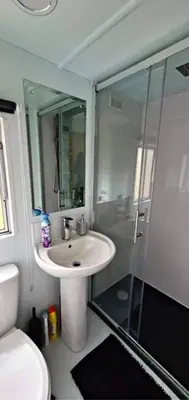 a bathroom with a sink and a glass shower at The Rabbit Hill Holiday Home in Ballantrae