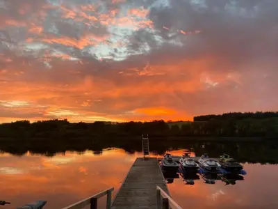a group of boats docked at a dock at sunset at The Inn on the Loch in Castle Douglas