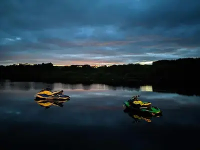 two boats sitting on a lake at dusk at The Inn on the Loch in Castle Douglas