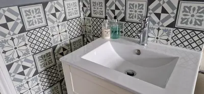 a white sink in a bathroom with tiles on the wall at Glencoe Guest House in Keswick