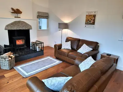 a living room with a couch and a fireplace at The Fish House in Kirkcudbright