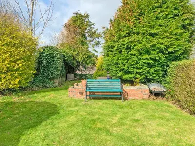 a blue bench sitting in the middle of a yard at Brae Cottage in Whithorn
