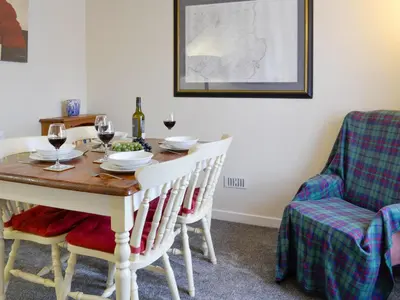 a dining room with a table with glasses of wine at Brae Cottage in Whithorn
