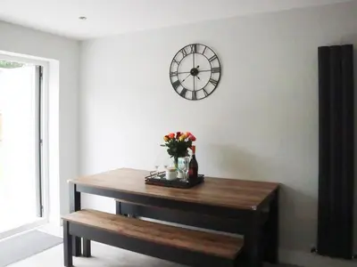 a table with flowers and a clock on a wall at 4 Mote View-Uk37497 in Sandhead