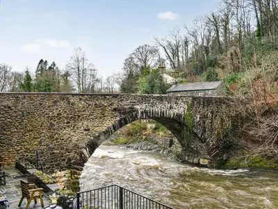 an old stone bridge over a river at Forge Cottage in Keswick