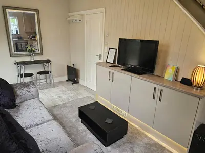 a living room with a couch and a flat screen tv at Carlisle Central, Cute Studio Appt, The Cupboard in Carlisle