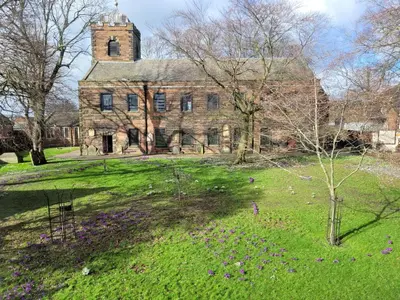an old stone building with a tower on top of a field at Carlisle Central, Cute Studio Appt, The Cupboard in Carlisle