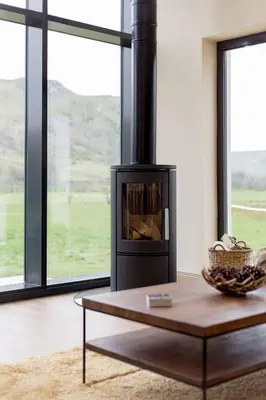 a living room with a fireplace and a coffee table at Balbeg Cottage in Straiton