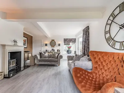 a living room with a large clock on the wall at Brooksyde,Kippford in Kippford