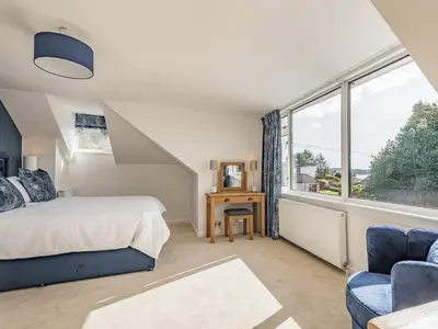 a bedroom with a bed and a large window at Brooksyde,Kippford in Kippford