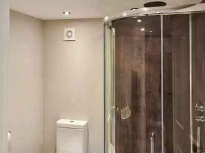 a bathroom with a toilet and a glass shower at Wallthwaite Cottage in Threlkeld