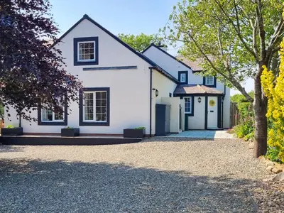 a white house with a driveway at Beacon Cottage in Ivegill