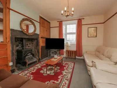a living room with a couch and a fireplace at Beckside Farm in Millom