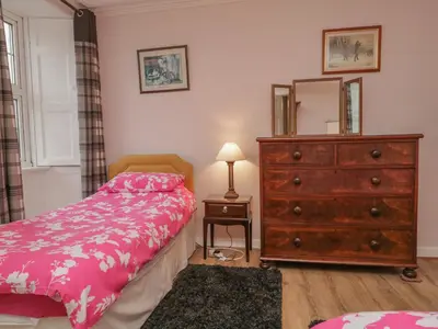 a bedroom with a bed and a dresser and a mirror at Beckside Farm in Millom