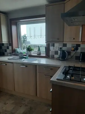 a kitchen with a sink and a stove and a window at Stunning Riverside Town House with views Ayrshire in Girvan