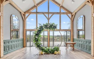 a room with a wedding arch in a building with windows at Enterkine Country House Resort in Annbank