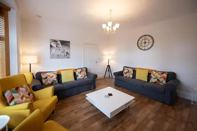 a living room with two couches and a table at The Prestwick Pad in Prestwick