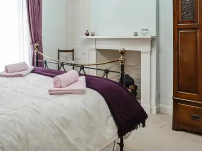a bedroom with a bed with pink towels on it at Sinclair's in Gatehouse of Fleet