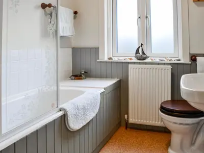 a bathroom with a tub and a toilet and a sink at Sinclair's in Gatehouse of Fleet