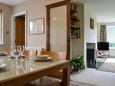 a dining room and living room with a table and chairs at Fell View in Lorton