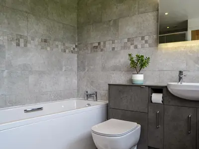 a bathroom with a tub and a toilet and a sink at Fell View in Lorton