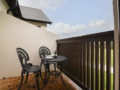 a small table and two chairs on a balcony at Tilly Mint Cottage in Penrith