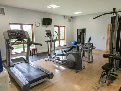 a gym with treadmills and exercise equipment in a room at Tilly Mint Cottage in Penrith