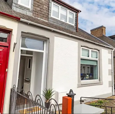 a white house with a red door at The Mila - Ayr Racecourse - Coorie Doon Stays in Ayr