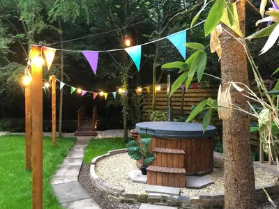 a garden with a hot tub under a string of lights at Ayrshire Airstream in Galston