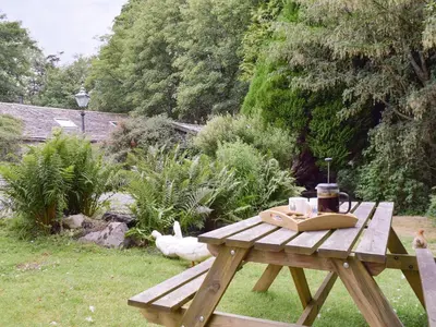 a wooden picnic table with a coffee maker on it at The Mill in Mungrisdale