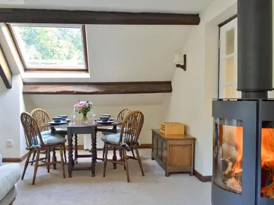 a dining room with a table and a fireplace at The Mill in Mungrisdale