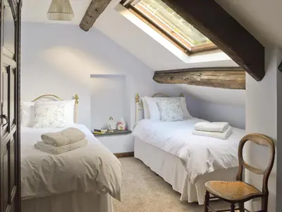 two beds in a attic bedroom with a skylight at The Mill in Mungrisdale