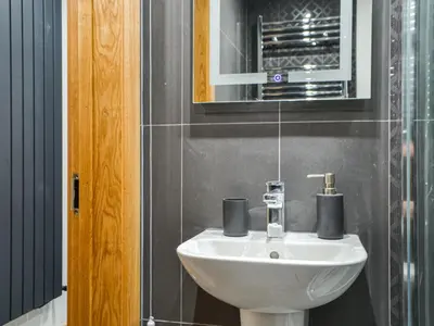 a bathroom with a white sink and a mirror at The Old Stable in Keswick