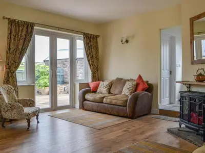 a living room with a couch and a fireplace at Old Saddlers Cottage in Ireby