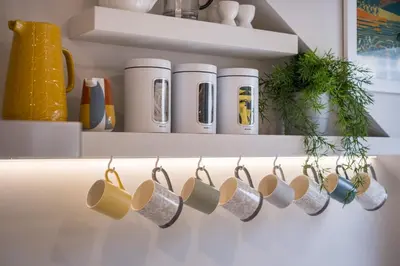 a rack of coffee mugs on a shelf in a kitchen at Howe Keld 6 Second Floor in Keswick