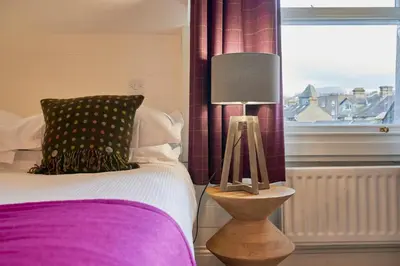 a bedroom with a bed with a lamp and a window at Howe Keld 6 Second Floor in Keswick