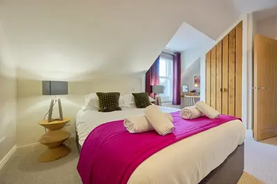 a bedroom with a large bed with a pink blanket at Howe Keld 6 Second Floor in Keswick