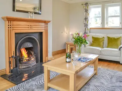 a living room with a fireplace and a couch at Knockinaam House in Colfin