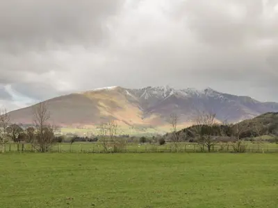 a large field with a mountain in the background at Sparrow Cottage in Keswick