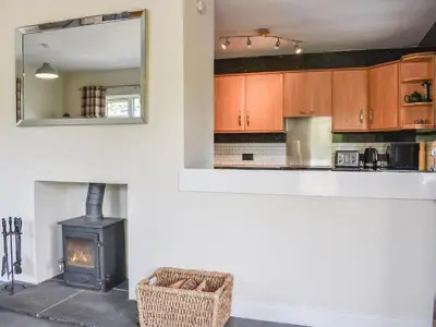 a kitchen with a wood stove and a mirror at Rosedean in Ireby