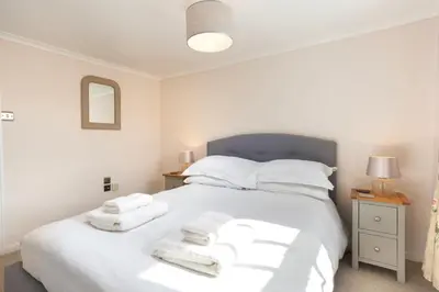 a bedroom with a white bed with towels on it at Rhubarb Cottage in Chapel Stile