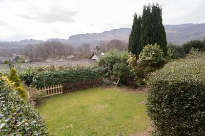 a garden with a fence and some bushes at Rhubarb Cottage in Chapel Stile