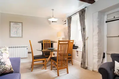 a living room with a dining room table and chairs at Rhubarb Cottage in Chapel Stile