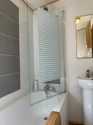 a bathroom with a tub and a sink and a mirror at Squirrel Lodge (Unit 7) in Carlisle